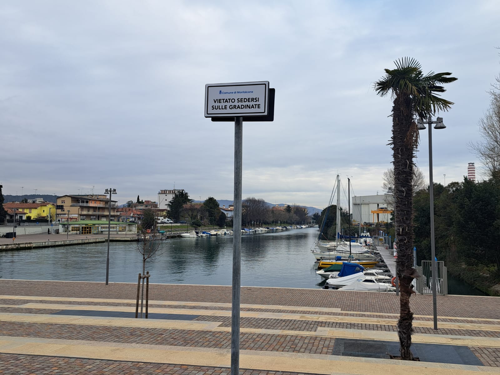 Immagine per ‘Vietato sedersi sulle gradinate’ del Porticciolo: il cartello equivoco infiamma la polemica a Monfalcone 